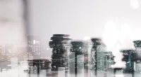 Collage image of stacks of coins and office skyline.