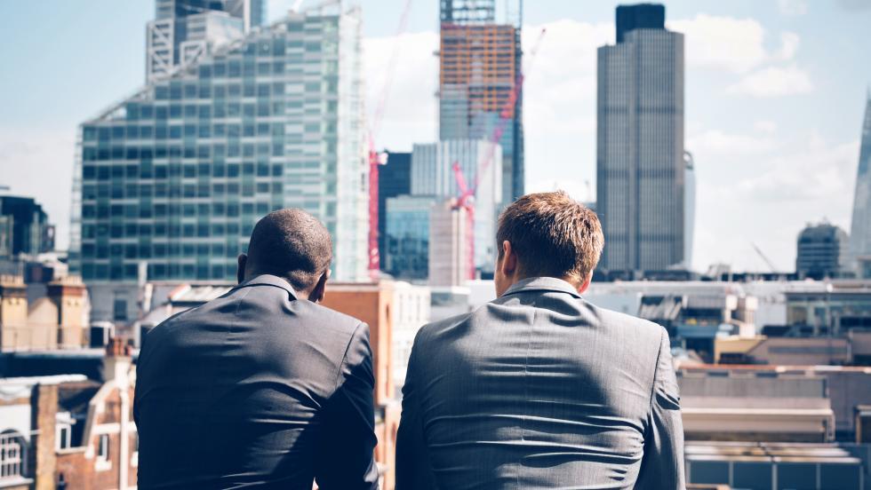 2 men staring at buildings being built